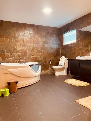 a bathroom with a tub and a toilet and a sink at Pelita Commercial Centre Homestay 百丽达商圈民宿 9pax in Miri