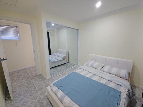 ein Schlafzimmer mit einem Bett und einem Spiegel in der Unterkunft Realhome in Blacktown