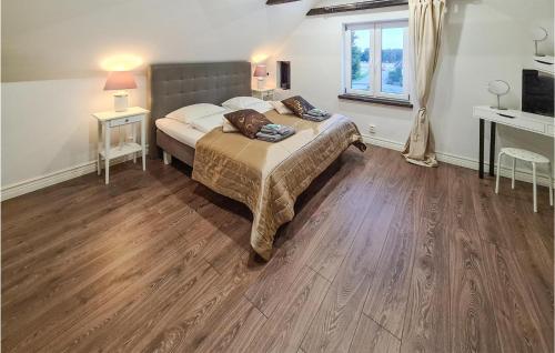 Schlafzimmer mit einem Bett, Holzböden und einem Fenster in der Unterkunft Awesome Home In Lövestad in Lövestad