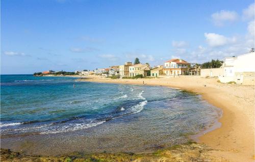 a sandy beach with houses and the ocean at Gorgeous Home In Comiso With Wifi in Comiso