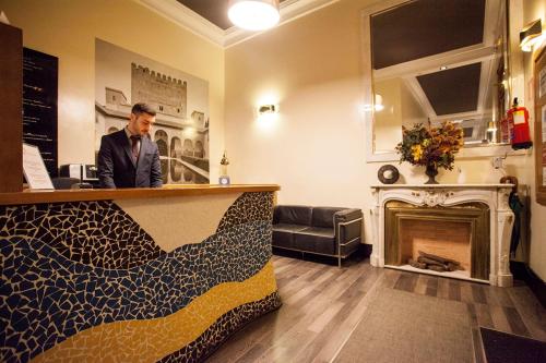 a man standing at the counter of a bar at Alhambra Suites in Madrid