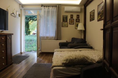 a bedroom with a bed and a sliding glass door at Pálma Apartmanok Szálláshely Százhalombatta 3a in Százhalombatta