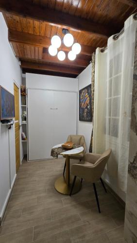 a living room with a table and a chair at Mini Studio Doré 10m2 in Massy