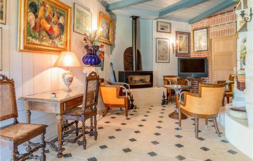 un salon avec une table, des chaises et une télévision dans l'établissement Nice Home In Morainville Jouvaux, à Morainville-près-Lieurey