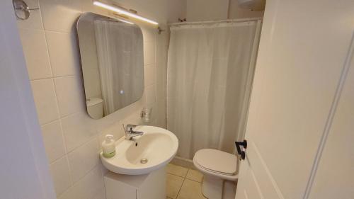 a bathroom with a sink and a toilet and a mirror at Messinian Aura in Arkondikó