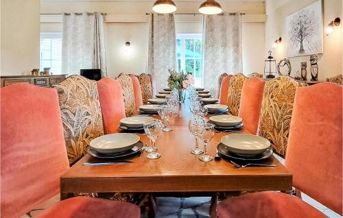 a long table with chairs and plates and glasses at Awesome Home In Colombieres With Wifi in Colombières