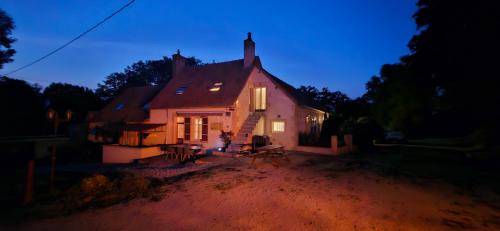 a small house is lit up at night at Le Coeur Du Moulin in Saint-Aubin-le-Monial