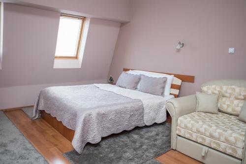 a bedroom with a bed and a couch at Sin-Kom Hotel Garni in Pirot