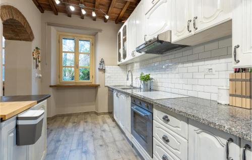 a kitchen with white cabinets and marble counter tops at Stunning Home In Capannori With Jacuzzi in Capannori