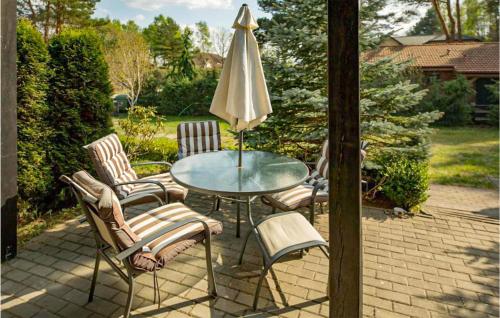 ein Tisch mit Stühlen und einem Sonnenschirm auf einer Terrasse in der Unterkunft 1 Bedroom Nice Apartment In Debina in Debina