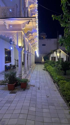 a building with white columns and lights at night at Hotel Sunbird in Bharatpur
