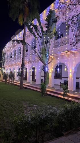 a white building with christmas lights on it at Hotel Sunbird in Bharatpur