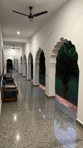 a hallway with arches and a tree on the wall at Hotel Sunbird in Bharatpur