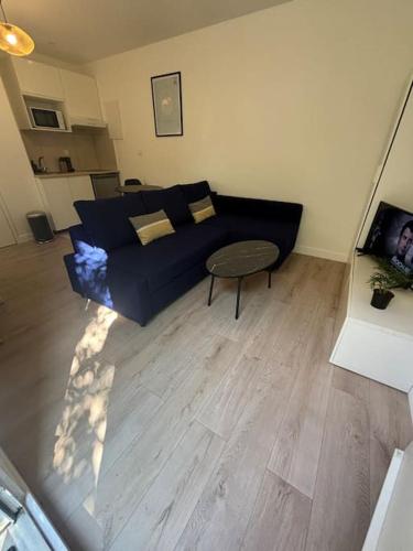 un salon avec un canapé bleu et une table dans l'établissement Le Nid Bleu, cœur des Minimes, à Toulouse