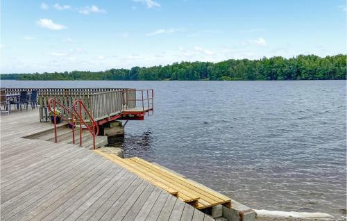 a dock with a bench on the side of a lake at Stunning Home In Tingsryd With Wifi in Tingsryd