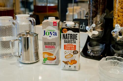 a counter top with milk and orange juice and a blender at Lamede SELF CHECK-IN in Wiener Neustadt
