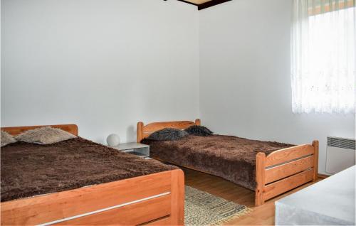 a bedroom with two beds and a window at Beautiful Home In Bozepole Krolewskie in Bożepole Królewskie