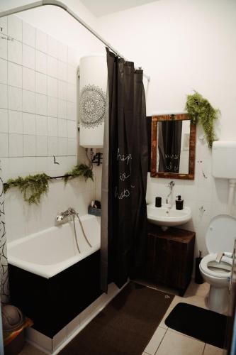 a bathroom with a tub and a toilet and a sink at Studio apartman Ars libri in Đakovo