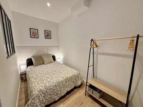 - une petite chambre avec un lit et deux photos sur le mur dans l'établissement Le Petit Hainaut, hyper centre, à Valenciennes