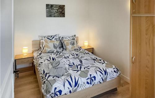 a bedroom with a bed with blue and white sheets at Joli Chalet Dans La Somme in Hem-Monacu