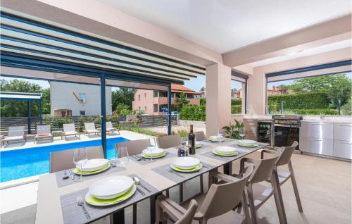 comedor con mesa, sillas y piscina en 4 Bedroom Amazing Home In Kadumi, en Kadumi