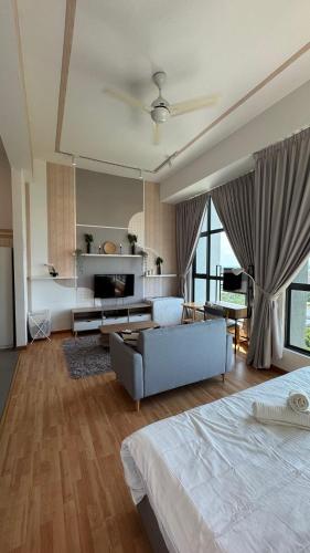 a bedroom with a bed and a living room with a couch at Dwin Studio Suites Imperium Residence Kuantan in Kuantan