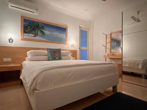 a bedroom with a large white bed in a room at Asseyri Guest House in Maradhoofeydhoo