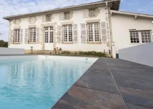 une maison avec piscine devant un immeuble dans l'établissement Domaine Bordenave, à Hinx