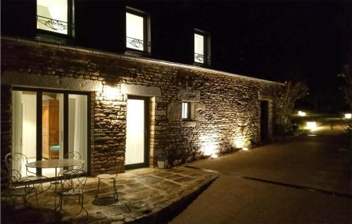 a brick building with a table and chairs outside at night at Amazing Home In Lanouee With Wifi in Lanouée