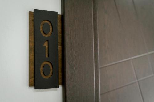 a clock on a wall next to a bathroom door at Lamede SELF CHECK-IN in Wiener Neustadt