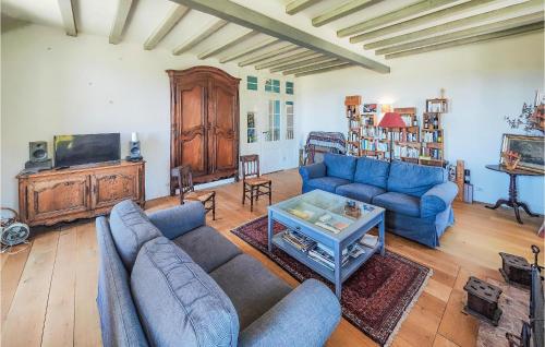 un salon avec des canapés bleus et une télévision dans l'établissement 5 Bedroom Beautiful Home In Ouveillan, à Ouveillan