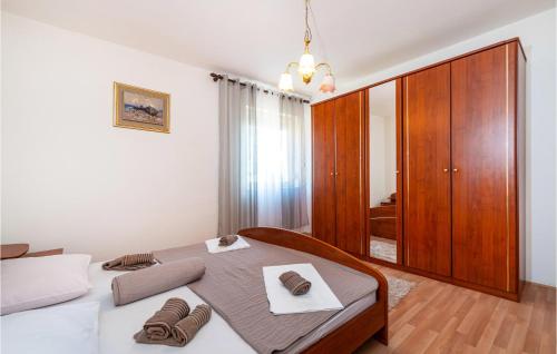 a bedroom with a bed and a wooden cabinet at 3 Bedroom Amazing Apartment In Jasenice in Jasenice