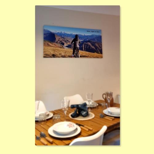 une table à manger avec une photo d'une personne faisant du vélo dans l'établissement Charmant T3 avec piscine, à Digne-Les-Bains