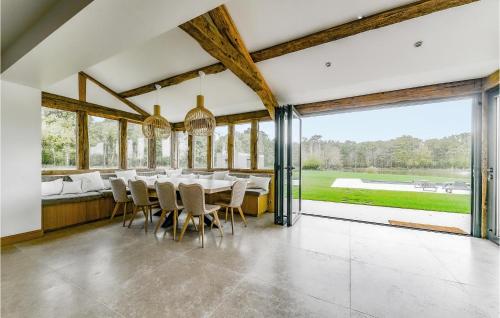 a dining room with a table and chairs and large windows at Cozy Home In Blancafort in Blancafort