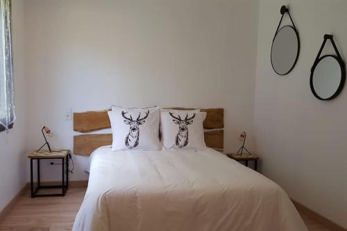 une chambre avec un lit blanc avec deux oreillers dans l'établissement Le Pti'Fernin, Gîte de Sologne, à Saint-Viâtre