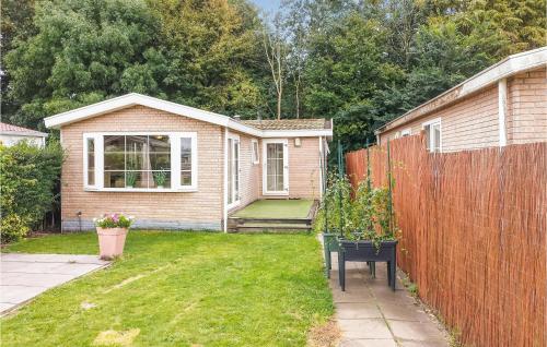 a small house with a fence in a yard at Nice Home In Heinkenszand With Wifi in Heinkensand
