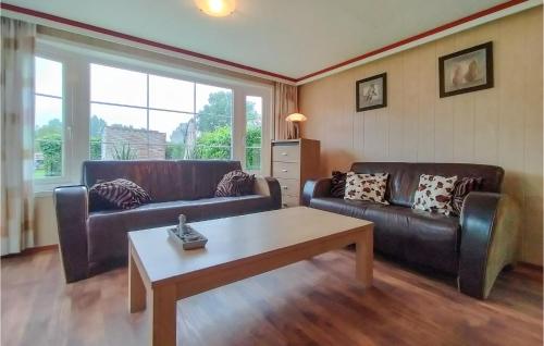 a living room with two leather couches and a coffee table at Nice Home In Heinkenszand With Wifi in Heinkensand