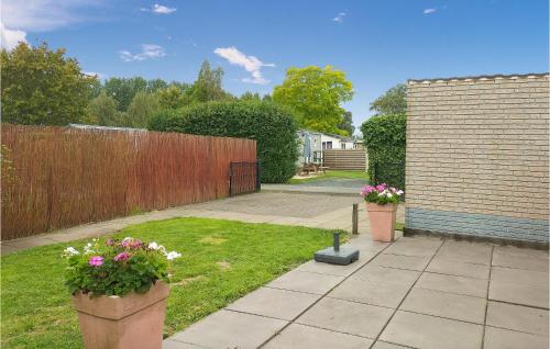 a backyard with two potted plants and a fence at Nice Home In Heinkenszand With Wifi in Heinkensand