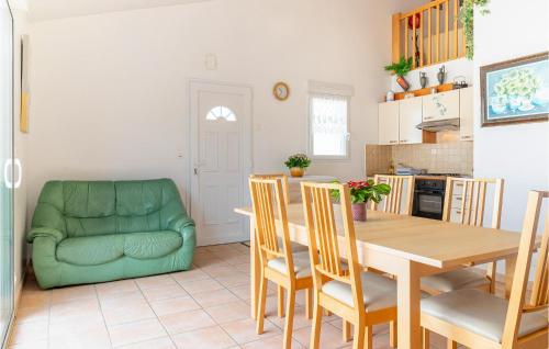 une cuisine et une salle à manger avec une table et un canapé vert dans l'établissement Awesome Home In La Faute Sur Mer, à La Faute-sur-Mer