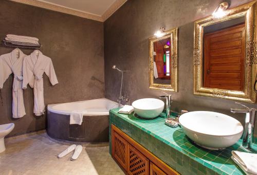 a bathroom with two sinks and a tub and a mirror at Riad Andalib in Fès