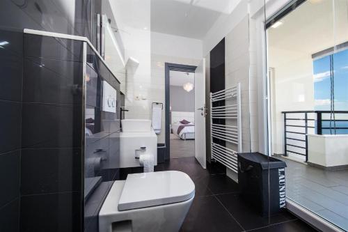 a bathroom with a toilet and a sink and a shower at Villa Red with pool and sea view in Makarska