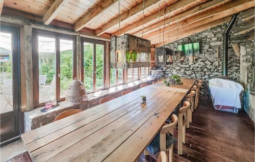a large wooden table in a room with windows at Lovely Home In Saint-Félix-De-L'héras in Saint-Félix-de-lʼHéras