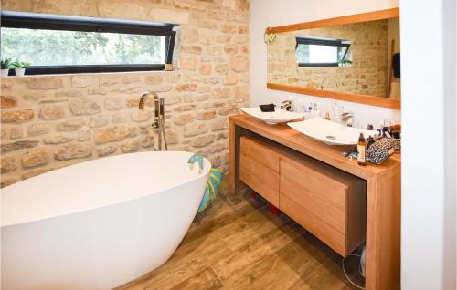 La salle de bains est pourvue d'une baignoire blanche et de deux lavabos. dans l'établissement Stunning Home In Orange, à Orange