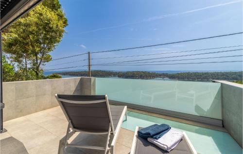 a chair sitting on the balcony of a house at Stunning Apartment In Rab With Kitchen in Rab