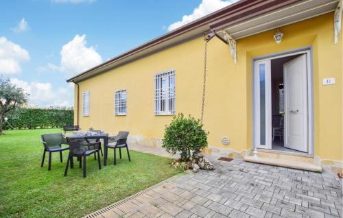 a yellow house with a table and chairs in the yard at Gorgeous Home In Capezzano Pianore in Capezzano Pianore,
