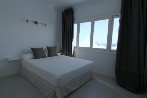 a bedroom with a white bed and a window at Costa Mar Sea View in Puerto del Carmen