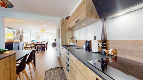une cuisine avec des placards en bois et une salle à manger dans l'établissement Villa le Bercail, à Saint-Gilles-Croix-de-Vie