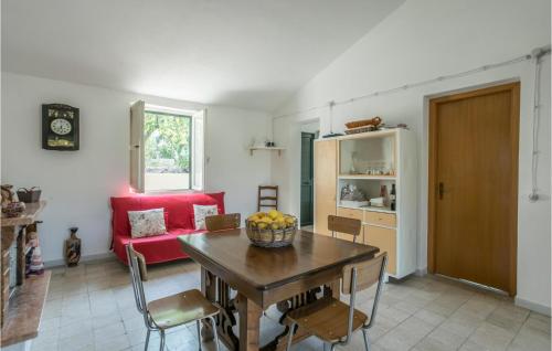 a living room with a table and a red couch at Beautiful Home In Noto in Noto