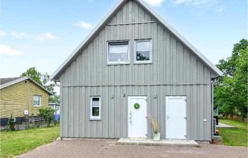 a gray garage with two white doors and a house at Stunning Home In Timmernabben With Wifi in Timmernabben