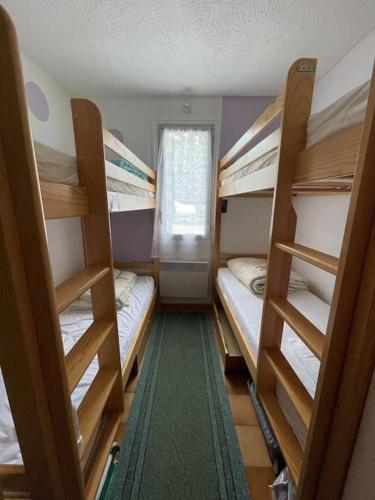 una habitación con tres literas y una ventana en Appt T2 à Saint-Lary-Soulan à 100m du centre, en Saint-Lary-Soulan